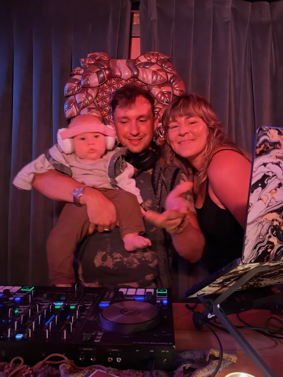 Samu, Kimmy, and baby Rhythm behind the DJ booth at Very Sacred Very Saucy
